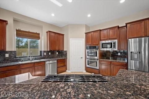 Culinary aspirations come alive in this kitchen, featuring stainless steel appliances and abundant granite counter space.