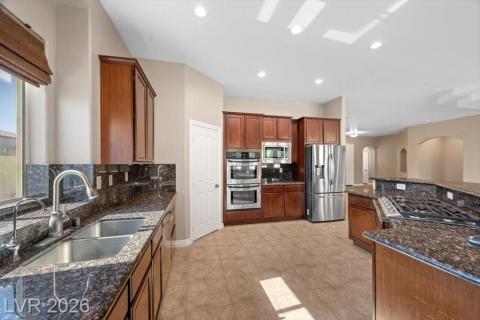 Granite counters and rich wood cabinetry define this well-appointed culinary space.