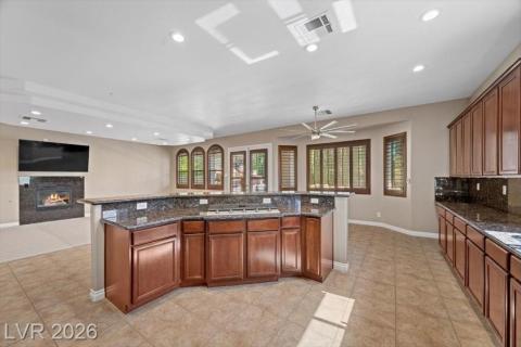 A well-appointed kitchen features a large island and ample cabinetry, opening to a spacious living area with a cozy fireplace.