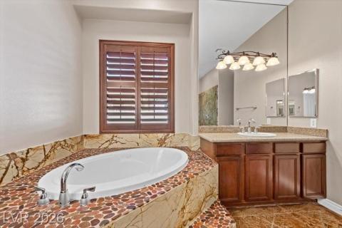 Indulge in a tranquil bathing experience with this deep soaking tub and stylish pebble tile surround.