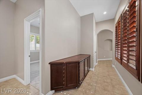 A well-appointed hallway with custom built-in cabinetry and warm tiled flooring awaits.