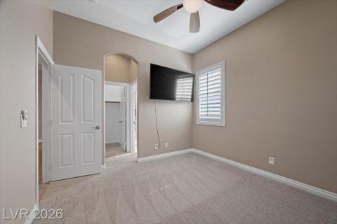 Well-lit sleeping quarters feature soft carpeting and a window with elegant plantation shutters.
