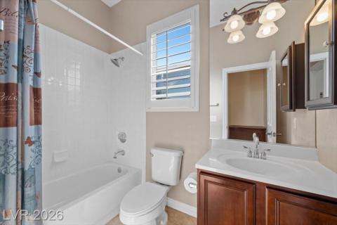 Bright, full bathroom includes a white vanity with rich cabinetry and a pristine tub-shower combo.