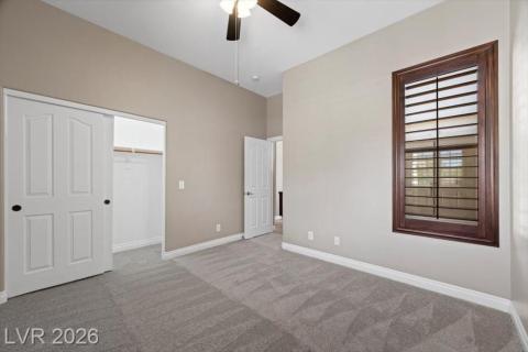 A well-lit bedroom with soaring ceilings offers a spacious, tranquil retreat.