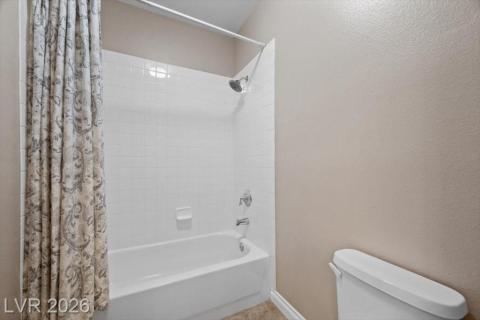 A pristine bathroom featuring a classic tub and shower combination with clean, white tiling.