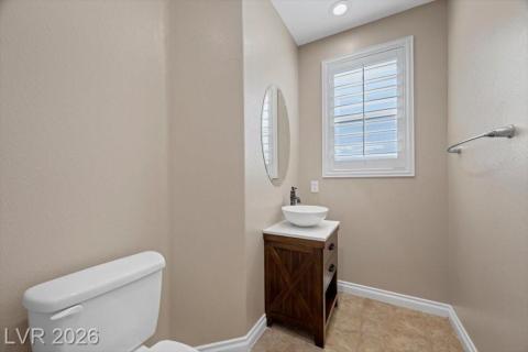 A well-lit powder room offers practical elegance with a charming vessel sink and natural light.