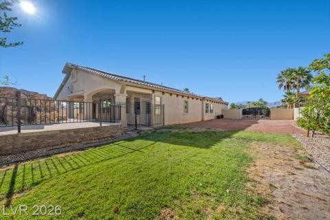 A spacious yard with mature landscaping and a well-maintained patio offers outdoor enjoyment.