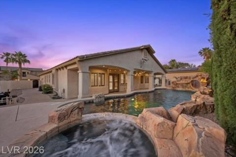 An inviting backyard oasis awaits, featuring a refreshing pool with rock-inspired waterfalls and a bubbling spa.