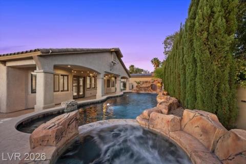 A spacious private pool and spa await under the twilight sky, framed by mature landscaping.
