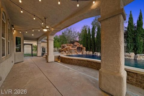A private covered patio and sparkling pool with a natural rock waterfall, perfect for tranquil evenings.