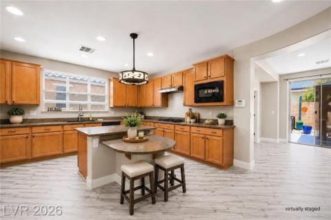 Kitchen with large island with bar seating, cooktop stove and built-in microwave Kitchen with large island with bar seating, cooktop stove and built-in microwave