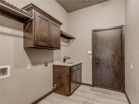LAUNDRY ROOM WITH HANGING BARS AND SINK
