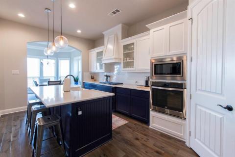 Two tone cabinetry and 5 burner gas cooktop make this kitchen a focal point. Glass front cabinets above add a nice touch. Large pantry.