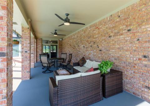 Covered back porch opens out to pool.