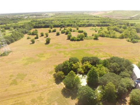 Drone photo of pond and lake in the back surrounded trees.
