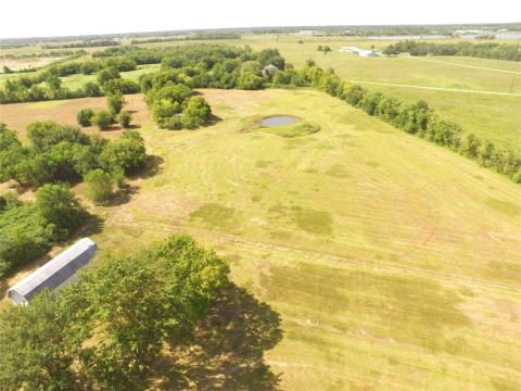 Drone photo of pond and metal storage building.